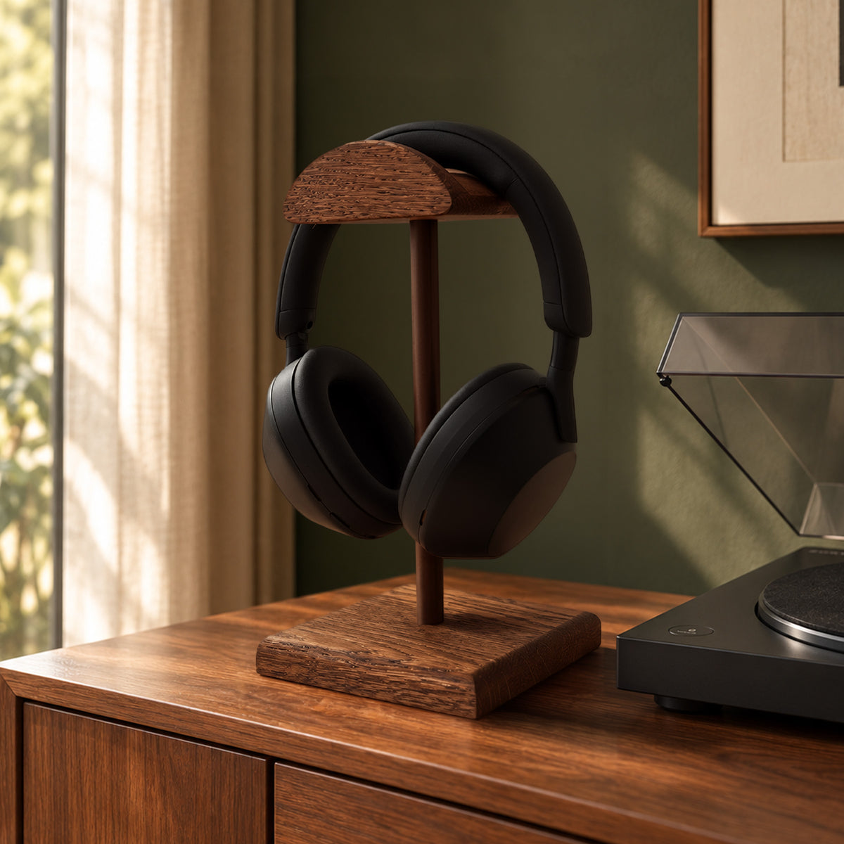 Repose casque en bois teinte noyer et tige rouille foncée laquée à côté d’une platine vinyle